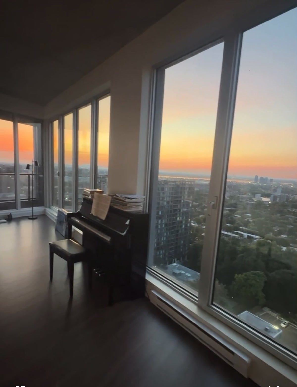 Un condo montréalais au coucher du soleil, vitrage pleine hauteur sans rien d’installé et le soleil bas qui remplit la pièce.